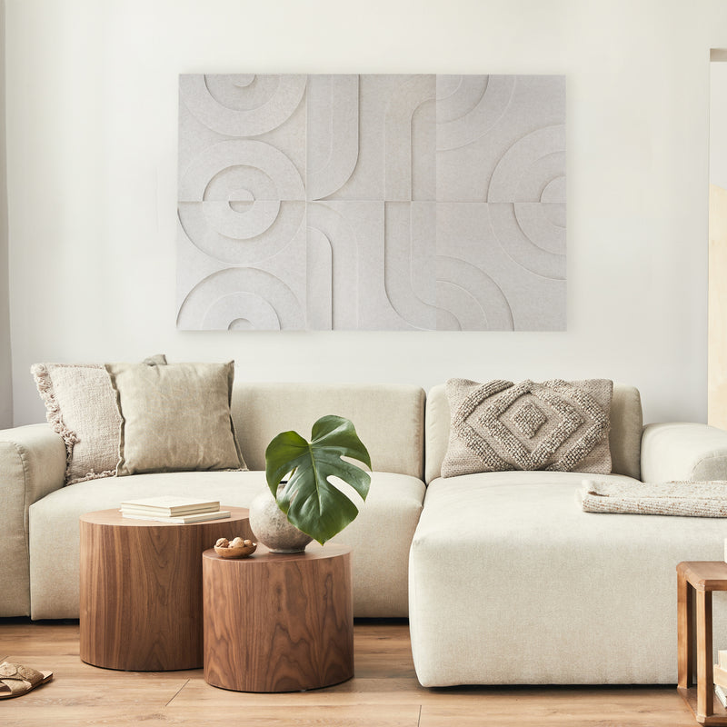 Maya aus akustischen Filzplatten in Beige – Bögen und Kreise im 3D-Relief – über dem weißen Sofa im Wohnzimmer